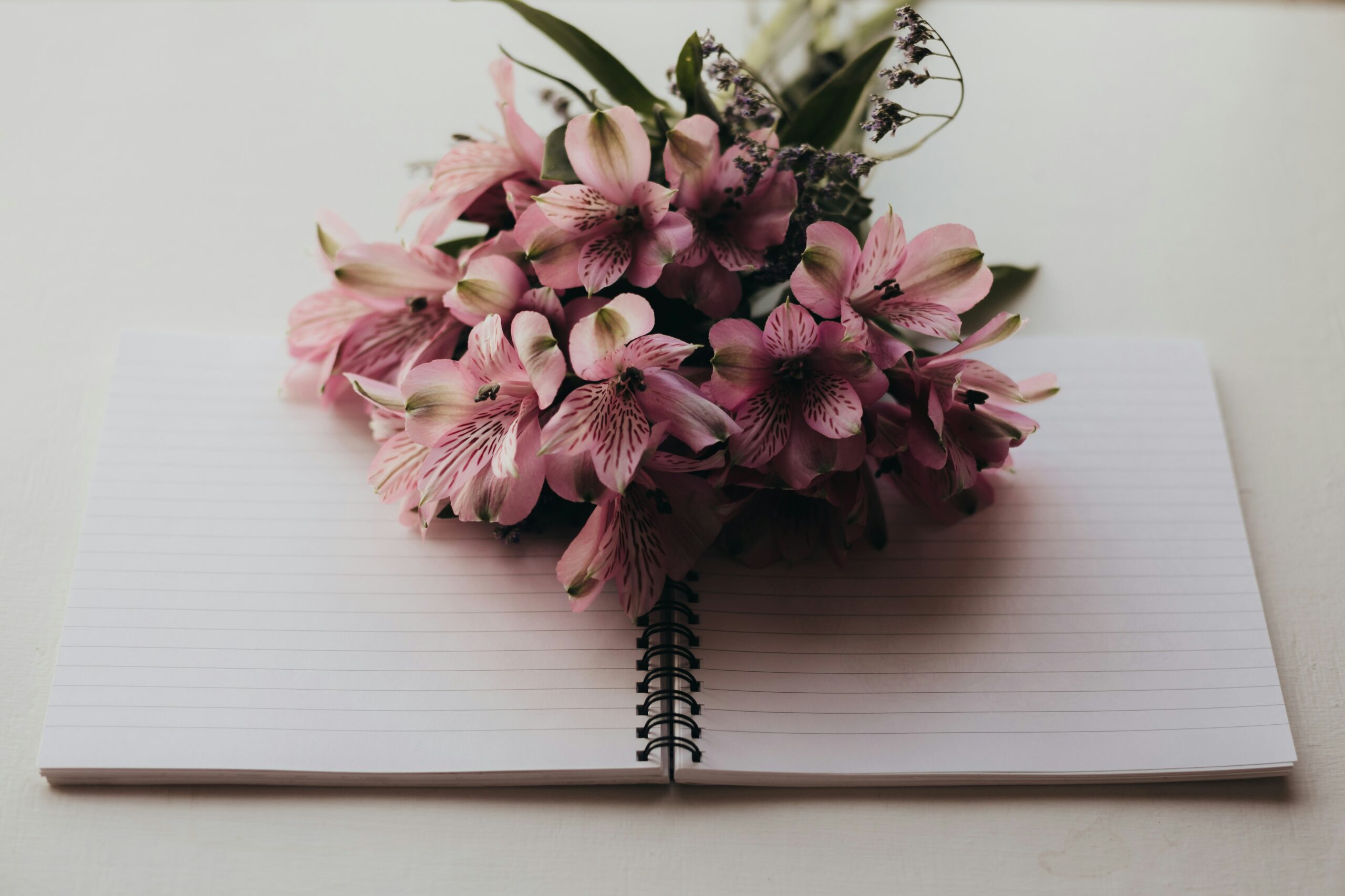 Image of flowers on a notebook to write your obituary
