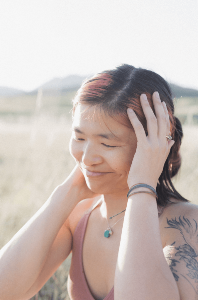 Niki DiGaetano, death doula and Chinese American, standing in a sunset field