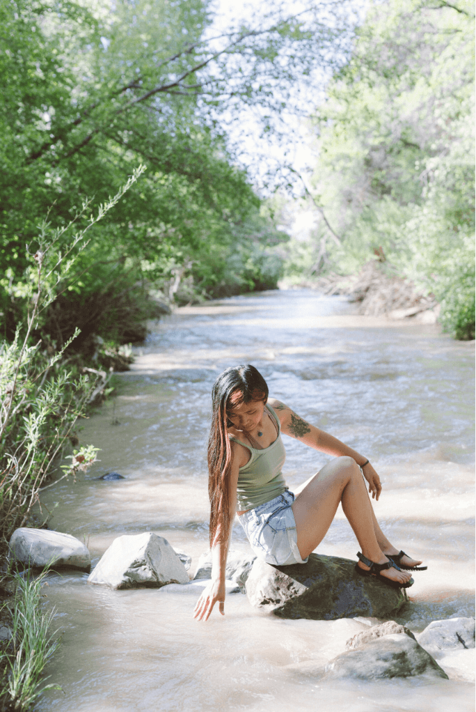 Niki DiGaetano, a death doula, sitting by the river