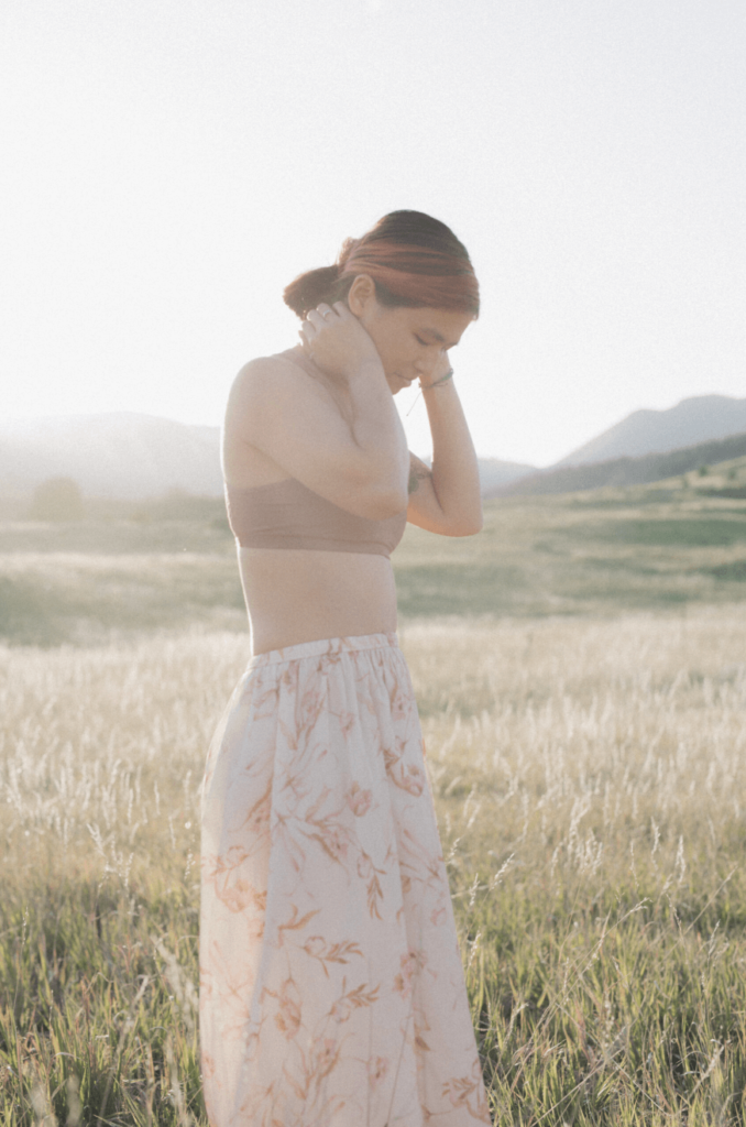 Lifestyle image of Niki DiGaetano, wearing a pink skirt and standing in a field